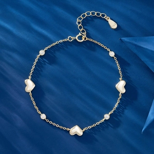 Detail of S925 sterling silver heart bracelet with white zircons on blue background