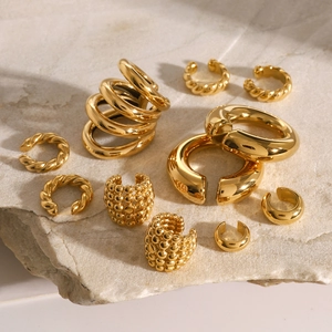 Set mit Vintage-Ohrklemmen in Goldoptik auf Marmor mit verschiedenen Texturen