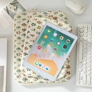 Minimalist floral quilted laptop sleeve and iPad case in various sizes on a desk