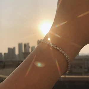 Close-up of sparkling silver tennis bracelet with rectangular crystals worn on wrist