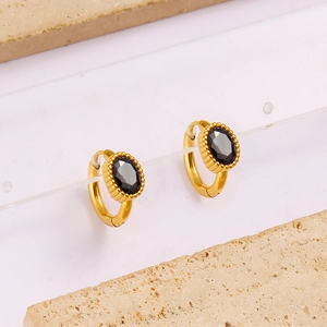 Macro shot of gold-plated oval hoop earrings with black zircon stone and beaded detailing