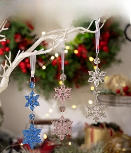 Close-up of colorful acrylic snowflake ornaments hanging on a festive white Christmas tree