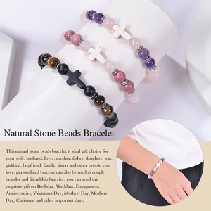 Détail de bracelets en quartz rose et améthyste de 8mm avec croix sur un présentoir blanc