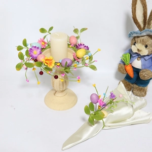 Detail of Easter candle ring with colorful eggs and silk flowers for spring table decor