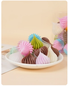 Colorful miniature spiral cream dollhouse cakes displayed on a white ceramic plate
