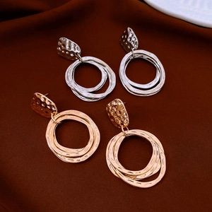 Detailed view of gold and silver geometric multi-circle earrings with hammered metal texture