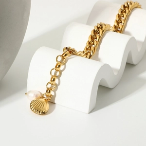 Gold-plated Cuban chain bracelet featuring a freshwater pearl and a metal shell charm
