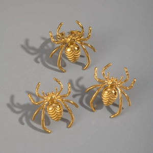 Detailed view of three polished gold spider-shaped rings with adjustable bands