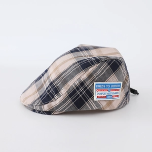 Detail of vintage plaid baby beret with fabric label and adjustable back strap