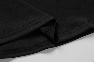 Detail of the double-needle stitching and fine knit texture on a black summer dress hem