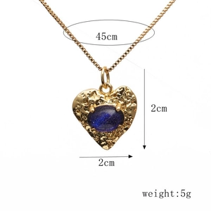 Close-up of golden heart pendant with hammer texture and blue stone, size 2x2cm