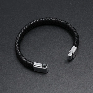 Macro shot of black braided leather bracelet featuring a polished silver magnetic clasp