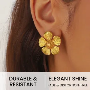 Close-up of gold plated five-petal flower stud earring with textured matte finish