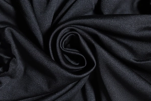 Dettaglio macro della trama del tessuto a maglia nera con eleganti pieghe e increspature