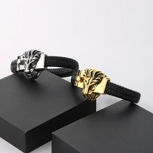 Close-up of woven leather bracelets with gold and silver lion head magnetic clasps