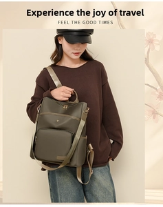 Detailed view of the dark olive green soft leather backpack on model in a warm setting