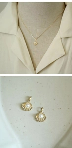 Macro view of French shell pendant necklace with white pearl and 14k gold plating