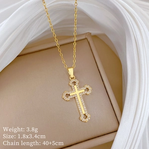 Detail view of gold hollow cross necklace with crystals on a beige display stand