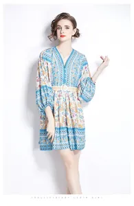 Detail of V-neck printed bohemian dress with lantern sleeves and belted waist styling