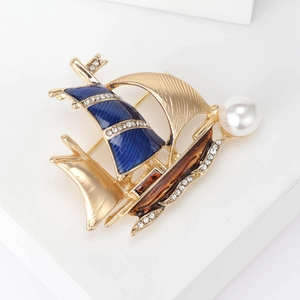 Detail of sailboat brooch with blue enamel, sparkling rhinestones and a white pearl