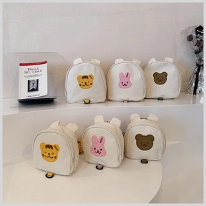Close-up of canvas kids' backpacks featuring embroidered tigers, rabbits, and bears