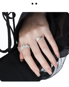Macro detail of textured silver ring with micro-set diamonds and blue gemstone on model hand