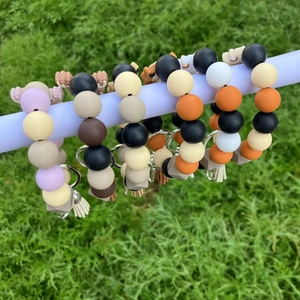 Outdoor display of silicone beaded keychains with colorful tassels and yak charm