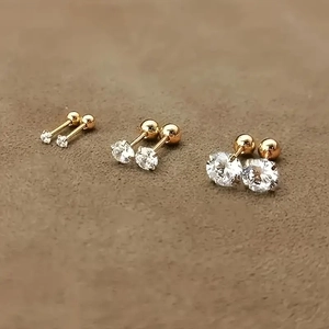 Three pairs of shiny gold stud earrings with round cubic zirconia in different sizes