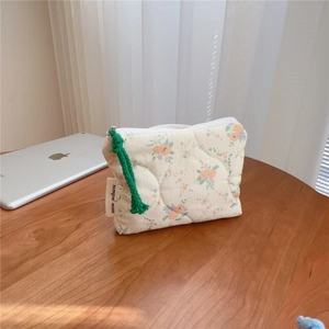 Close-up of quilted floral cotton coin purse with simple wish label on wood table