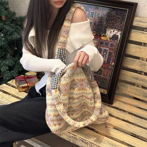 Detailed shot of a colorful plush tote bag with checkered accents on a wooden bench