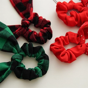 Detail of Christmas plaid and red scrunchies with bunny ears on a white surface