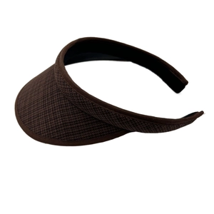 Detail view of woven dark brown sun visor with textured braid and elastic headband