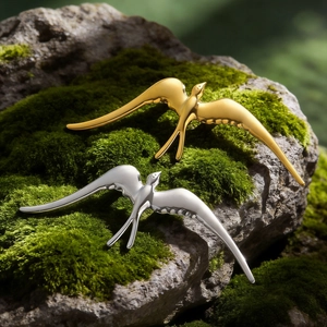 Broches d'oiseau hirondelle en acier poli or et argent sur mousse naturelle verte chic