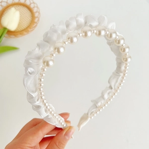 Detail of double-layer headband with white pleated satin fabric and faux pearls