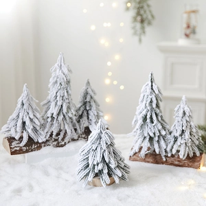 Miniature snow-flocked Christmas trees on wooden bases for festive tabletop decor