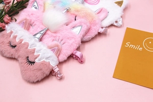 Close-up of colorful plush unicorn sleep masks with silver horns and soft texture