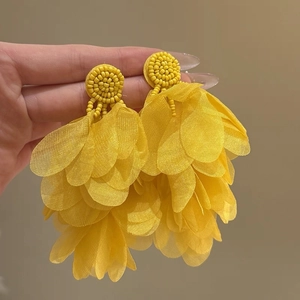 Detailed view of yellow bohemian layered fabric petal earrings with beaded accents