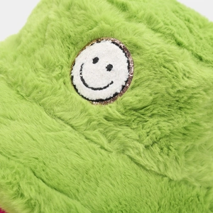 Close-up of green plush bucket hat featuring a fluffy texture and a round smiley face patch