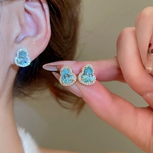 Vue macro de la boucle d'oreille hulu avec pierre bleu sarcelle et détails pavé en cristal
