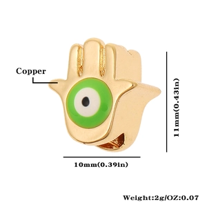 Macro view of 18K gold plated copper Hamsa Hand charm with evil eye detail and size specs