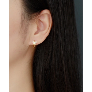 Elegant gold butterfly stud earrings with sparkling diamonds on a female model