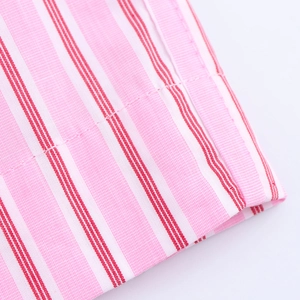 Macro shot of pink and red striped fabric showing texture and stitching details
