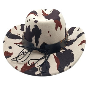 Detail of western cow print fedora hat featuring black leather band and metal buckle