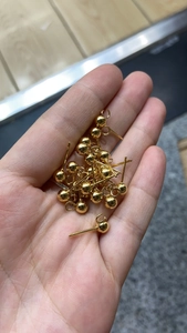 Close-up of gold plated stainless steel ball ear studs with loops for DIY jewelry making