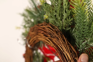 Macro detail of Christmas wreath showing natural rattan base and pine needle textures