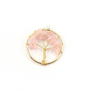 Detailed close-up of handmade golden tree of life pendant with pink crystal stones