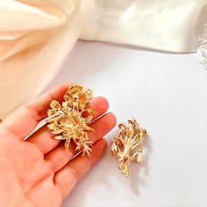 Detail of vintage enamel poppy and pearl brooch with golden flower and lily of the valley