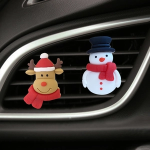 Close-up of reindeer and snowman silicone car air freshener clips on the vent