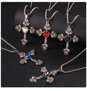 Detailed view of five rose cross necklaces with colorful heart crystals on leather