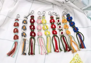 Macro detail of various handmade macrame flower keychains with tassels and metal lobster clasps